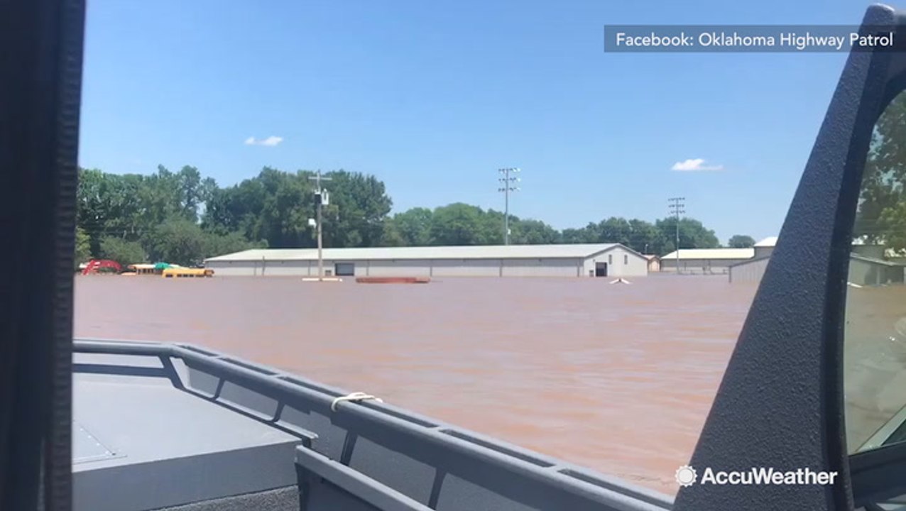 Boats maneuver through flooded street as feet of water sweeps through town