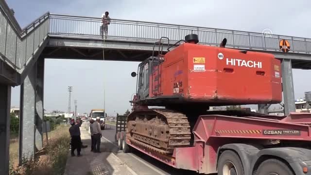 Dorsesinde iş makinası bulunan tır üst geçide takıldı