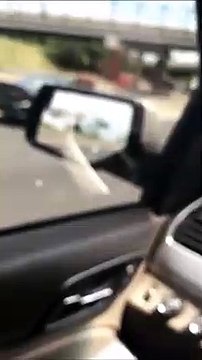 Un idiot s'amuse à la fenetre de sa voiture sur l'autoroute et chute