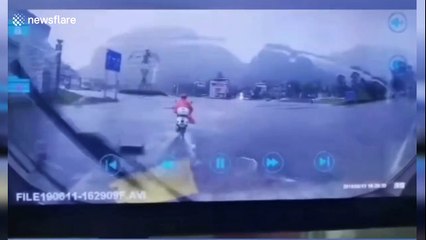 Lightning strikes ground inches away from scooter driver in China