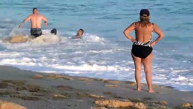 Il essayent de sortir une femme des courants des vagues à la plage !