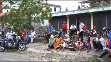 Indonesian teenagers attempt to play soccer in the thick mud of a rice field