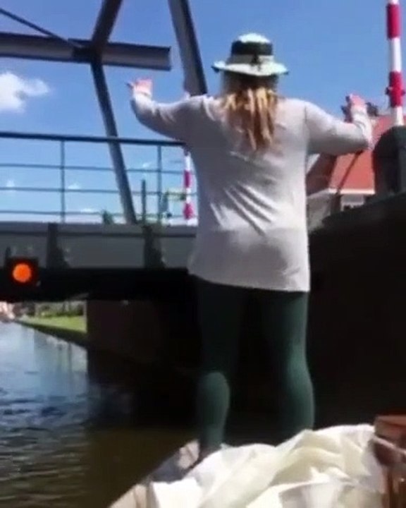 Une fille sur un bateau veut grimper sur un pont pour revenir sur le bateau