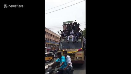 Terrifying moment celebrating students fall from top of moving bus in southern India