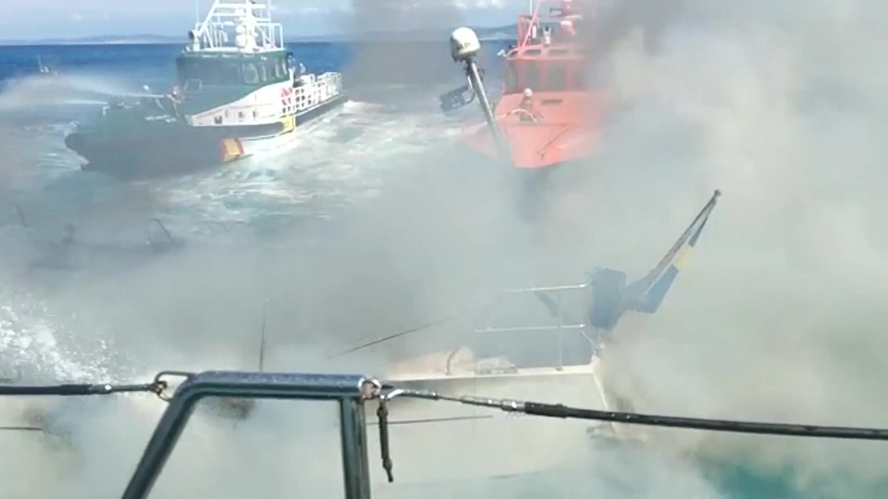 Trabajos de extinción de un velero sueco incendiado cerca de Malpica (A Coruña)