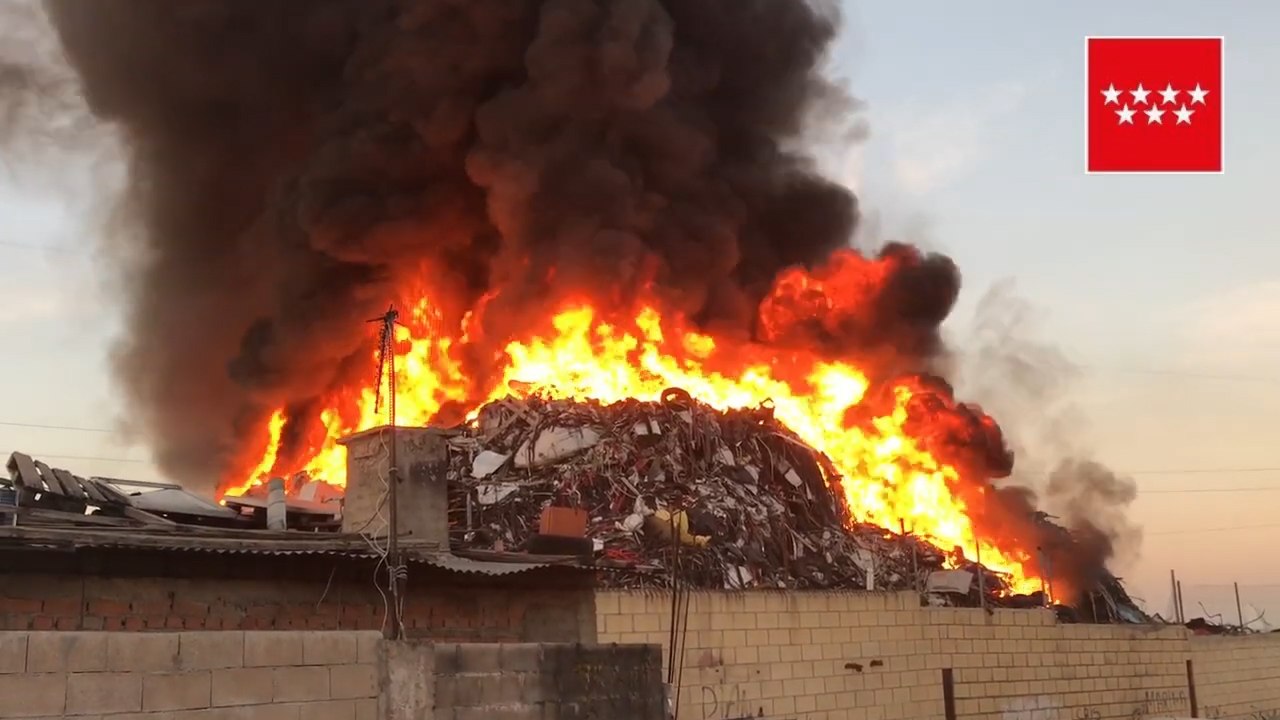 Bomberos trabajan en la extinción de una montaña de chatarra