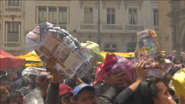 Miles de devotos en Bolivia piden al dios de la abundancia que les conceda los pequeños artículos pero en tamaño real