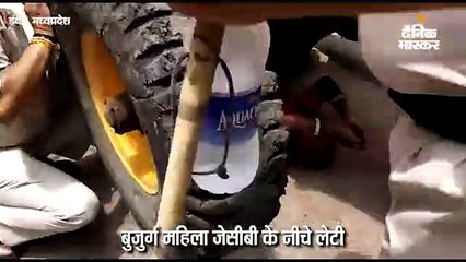 बुजुर्ग महिला जेसीबी के नीचे लेटी