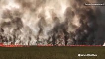 Lightning-sparked brush fire spreads through field
