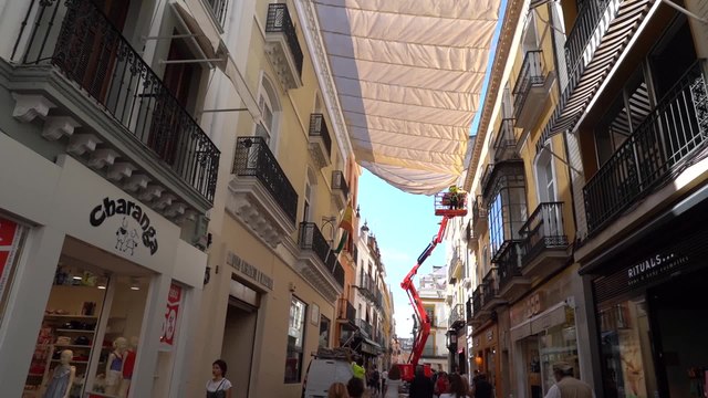 Colocación de los toldos en el centro de Sevilla desde Sierpes