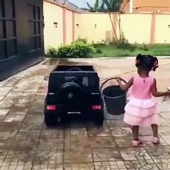 Cette petite fille adore prendre soin de sa voiture. Admirez la !