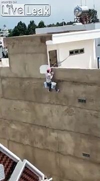 Cet ouvrier peint l'immeuble suspendu dans le vide sans sécurité !