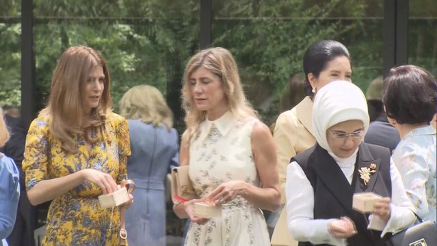 Imagen de las esposas dando de comer a los peces durante el G20.