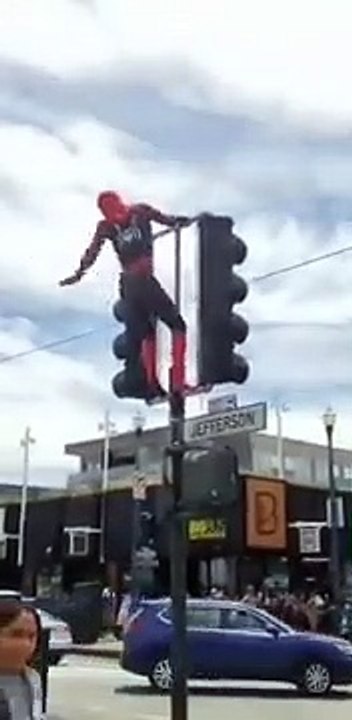 Spider man in America streets salute people with sexy dance during climbing traffic lights