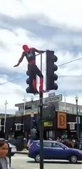 Spider man in America streets salute people with sexy dance during climbing traffic lights