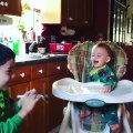 Toddler Laughs as Elder Brother Entertains by Blowing Party Whistle