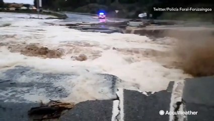 Road crumbles against rushing floodwater in Spain
