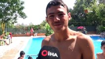 Türk ve Suriyeli gençler havuzda yüzerek serinliyor