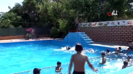 Türk ve Suriyeli gençler havuzda yüzerek serinliyor
