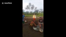 Shocking moment locals ride endangered leatherback turtle on Indonesian beach