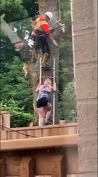 Ce bûcheron fait tomber sa tronçonneuse sur une femme qui lui tient l'échelle