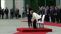 Merkel escucha el himno nacional sentada tras varios episodios de temblores