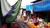 Un marché Thailandais au milieu d'une voie de chemin de fer. Attention au train