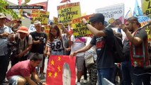 Protesters burn a Chinese flag in a rally outside the Chinese Consulate in Makati