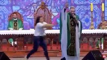 Una mujer empuja y tira del escenario a un famoso sacerdote de Brasil
