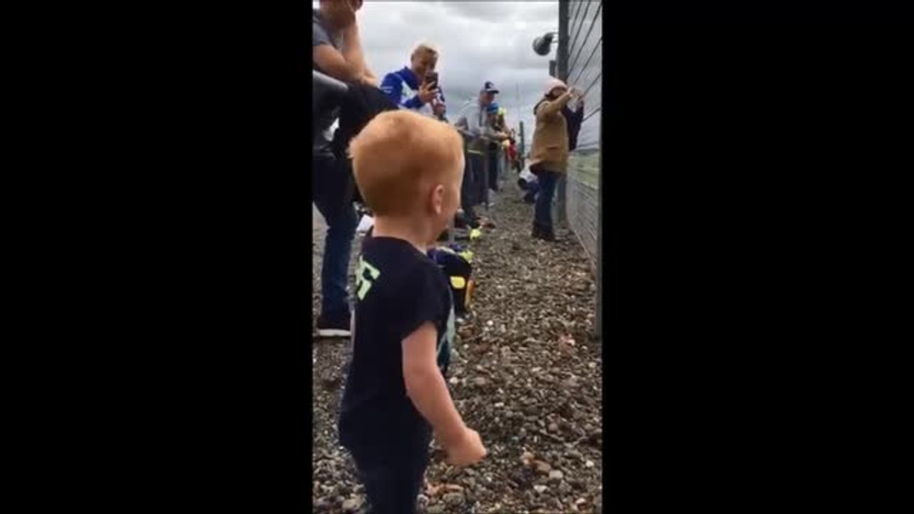 Logan Cox reacts to motorbikes at the Moto GP at Silverstone
