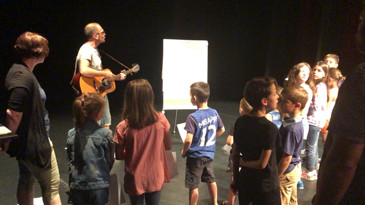 Le chanteur Mazarin fait répéter les enfants des forains avant le concert de comptines ce vendredi