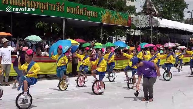 Adorable moment dozens of Thai schoolgirls dance on unicycles at Buddhist festival