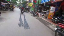 Motorbike stops traffic while dragging 6-metre long bundle of steel through crowded street