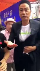 Simon Yam tries to move away while clutching his wounded abdomen