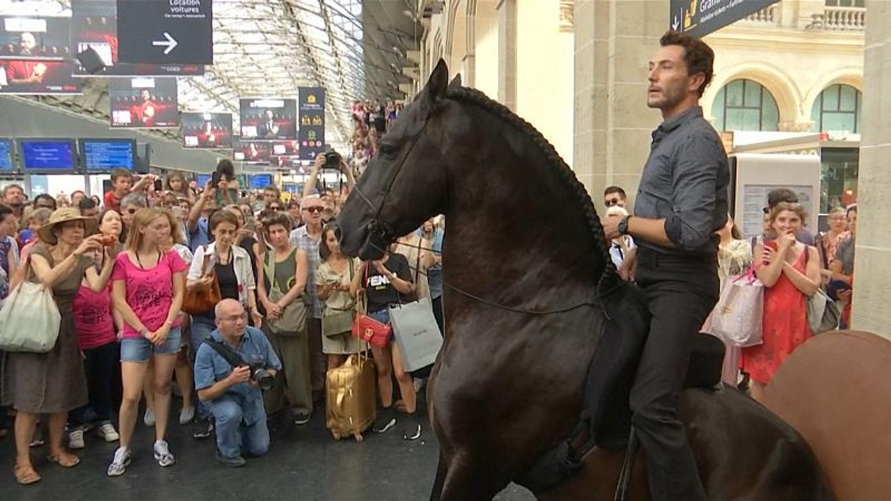 Performers on horseback surprise passengers at Paris train station