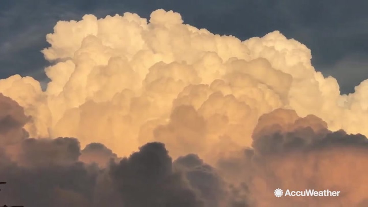 Beautiful billowing clouds turn bright orange at sunset