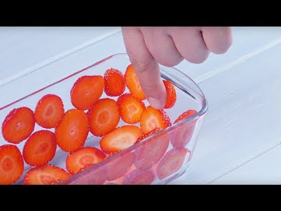 Beklebe die Glasform vollständig mit Erdbeeren. Dann ...
