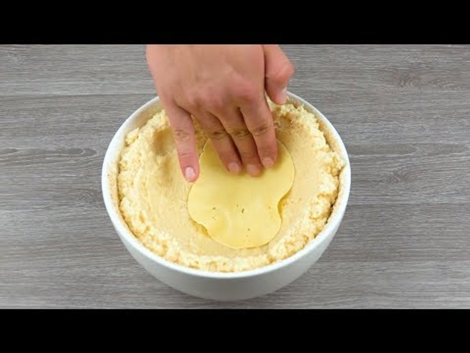 Er legt 10 Scheiben Käse in die Schüssel und kippt Risotto darüber. Das wird mega lecker!