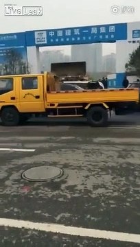 Un ouvrier en colère pousse des voitures mal garées avec sa pelleteuse