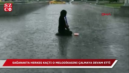 Yağmura aldırmadan melodikasını çaldı