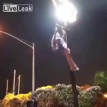 Une jolie demoiselle en mini jupe fait des tractions sur un lampadaire