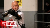 Police officer waves gun at Hong Kong protesters