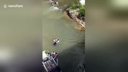 Residents save people trapped in car after it flips over into river in China