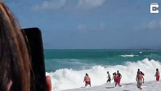 Un sauveteur intervient pour sortir un enfant piégé dans des vagues énormes
