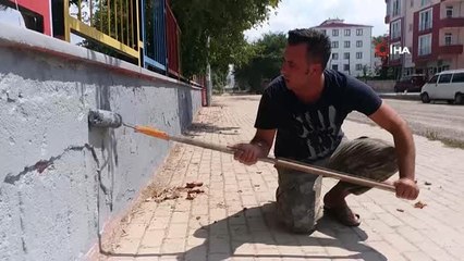 Okul müdürü elinde fırçayla okulu boyuyor