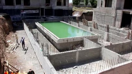 Sıcaktan bunalan işçiler havuz inşaatında serinliyor