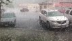 Hail plummets into the ground battering standing vehicles