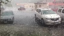 Hail plummets into the ground battering standing vehicles