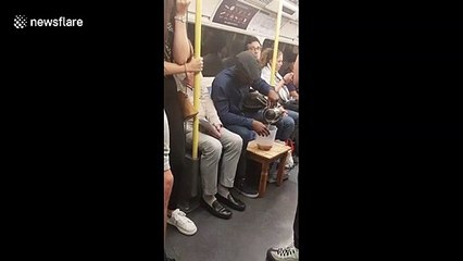 UK man makes a cup of tea with a jug and kettle while on the tube
