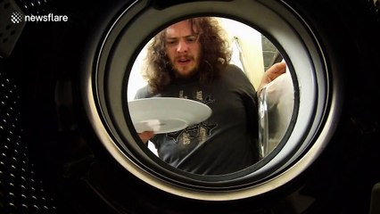 Man loads washing machine with dirty dishes